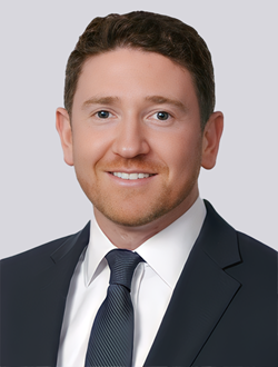 Professional man in a suit smiling against a neutral background, ideal for business or corporate profiles.