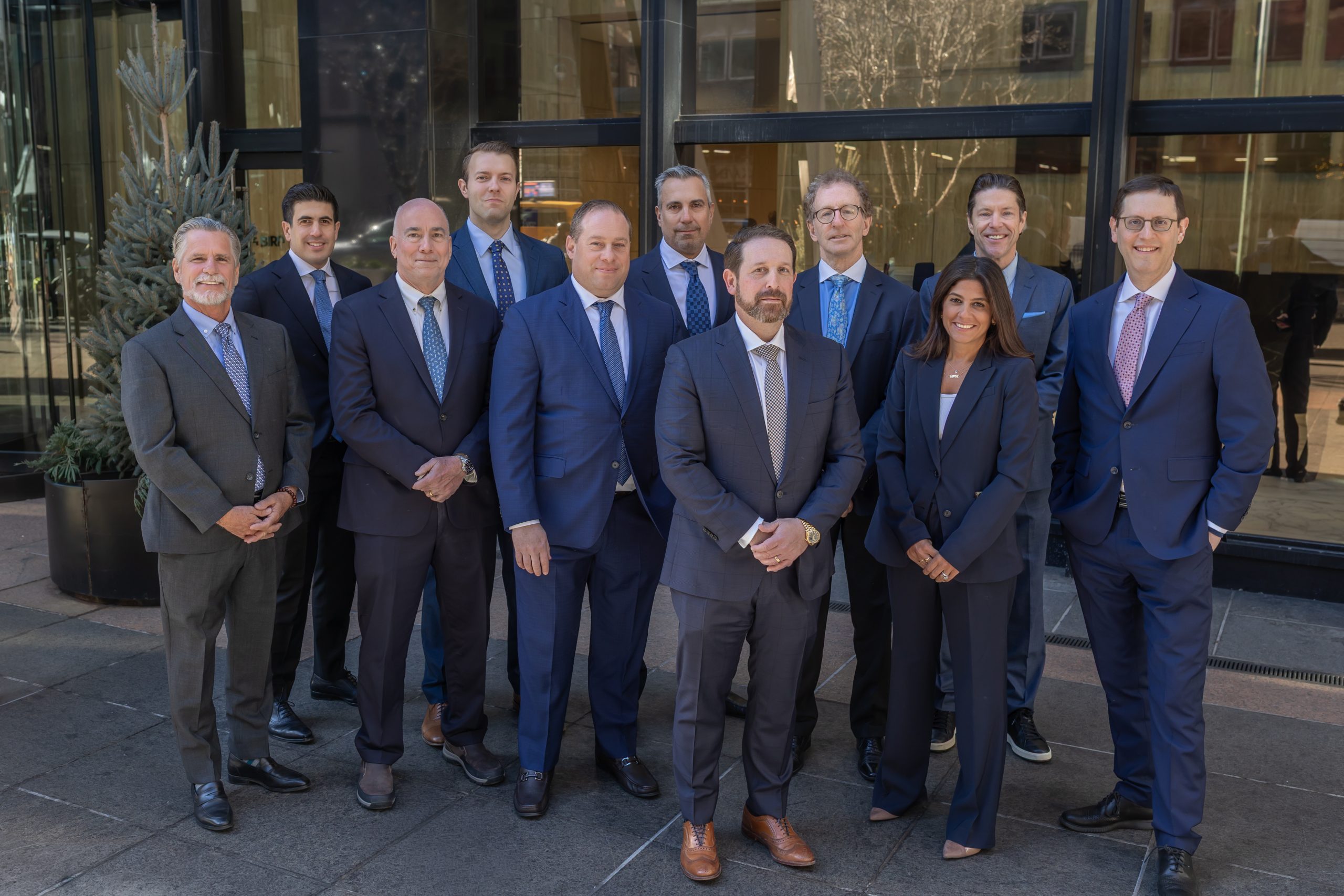 Business professionals posing in formal attire outside office